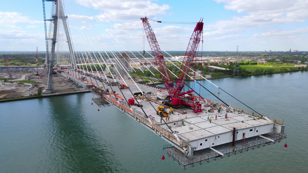 Unfinished Gordie Howe international bridge over Detroit river in drone shot