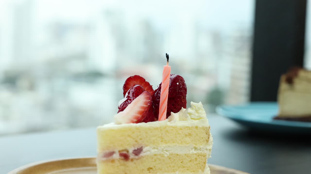 Single slice of strawberry shortcake with candle blown out, natural daylight, shallow depth of field