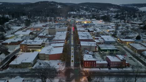 aerial orbiting shot of snowflakes falling on small town in america