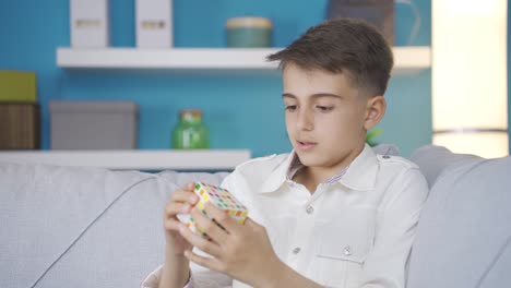 un chico inteligente tratando de hacer un juguete de rompecabezas en casa solo.