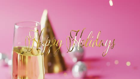 animation of happy holidays text over party hat and champagne glass