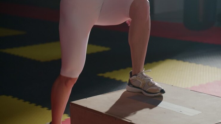 Woman Performing Step-Up Exercise on Box in Gym