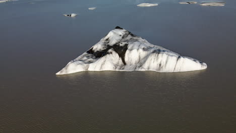 Toma-Aérea-En-Círculos-De-Un-Trozo-De-Hielo-Roto-De-Un-Glaciar,-En-Islandia,-Heinabergsjökul