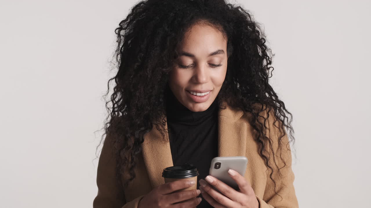 Young businesswoman enjoying coffee to go in front of camera.