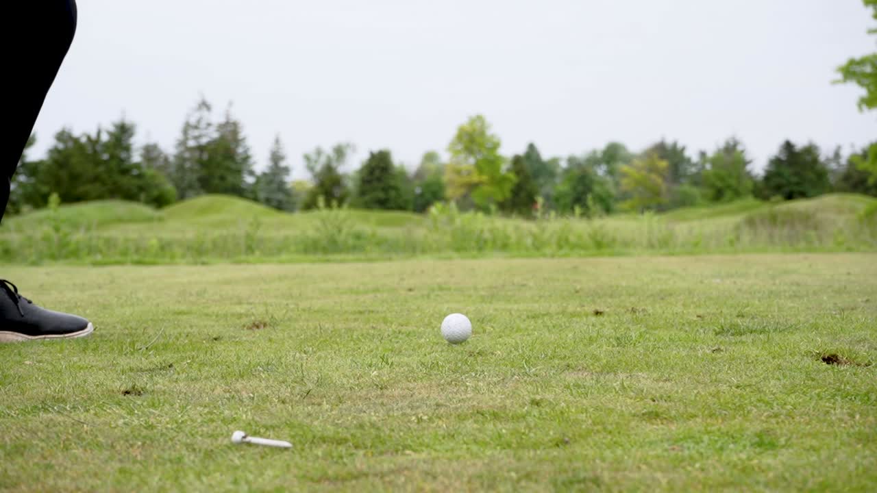 골퍼가 철로 티의 골프 공을 때리는 느린 동작  ⁇