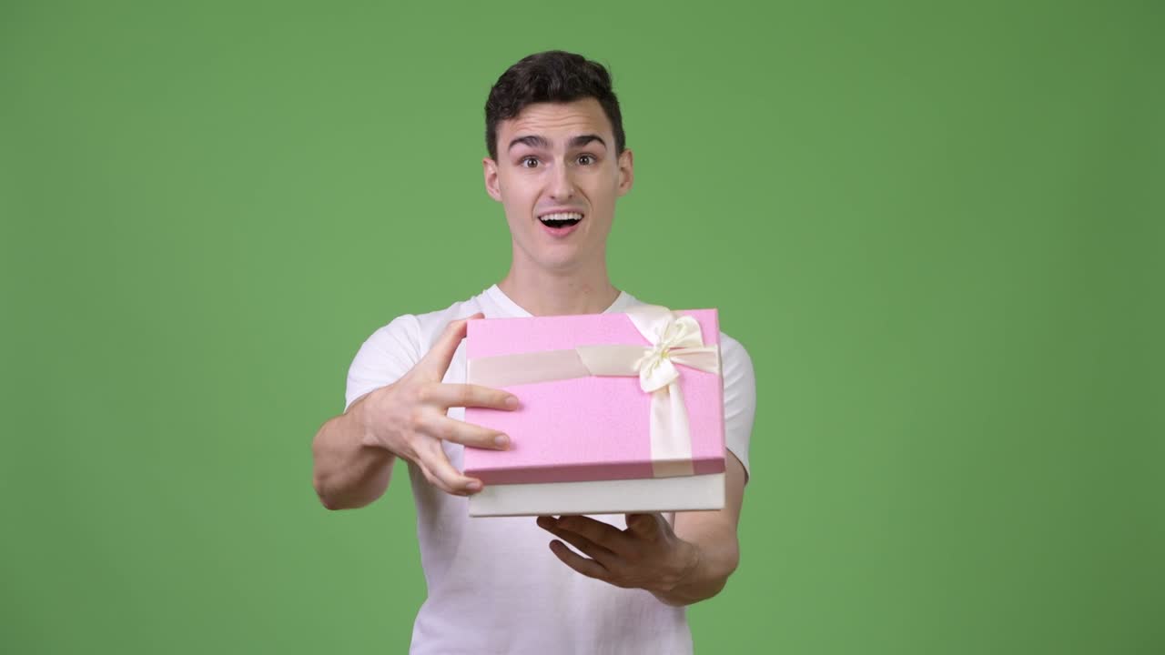 Young surprised man opening gift box