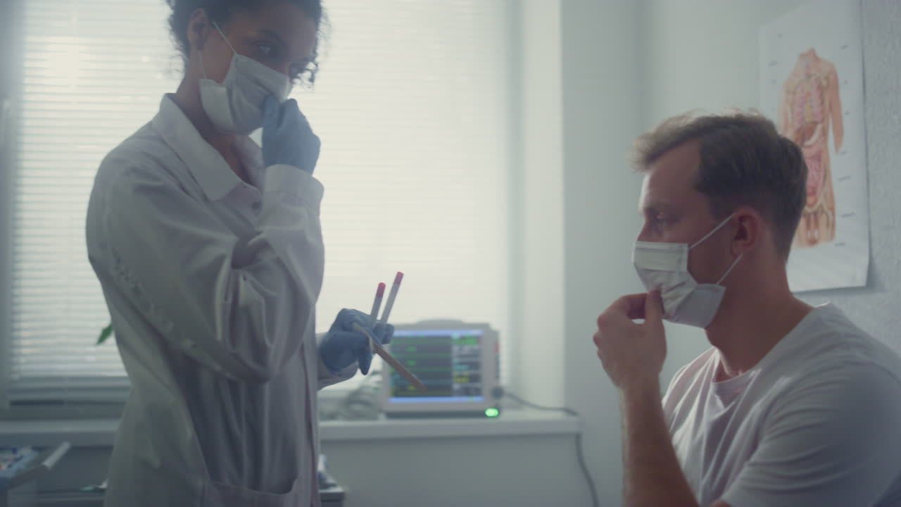 Medico professionista che preleva un campione dal naso di un uomo in primo piano. Il paziente si sottopone al test COVID-19