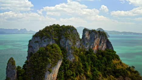 drone circling around small green overgrown island with rocks, aerial