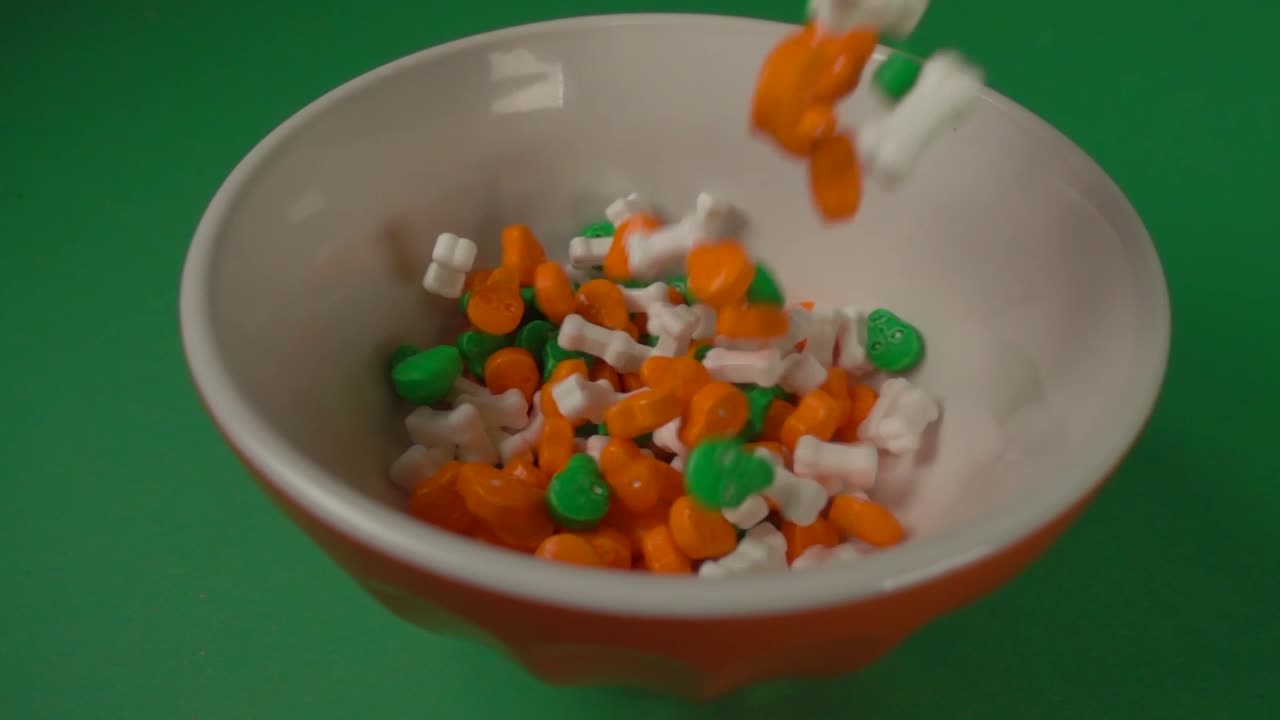 dulces en forma de huesos y calaveras cayendo sobre un plato