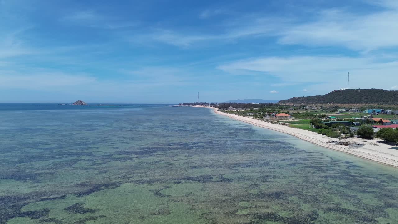 Drone shot zooming in towards the shoreline, capturing the textures of sand and water in My Hoa Lagoon, Phan Rang, Vietnam.