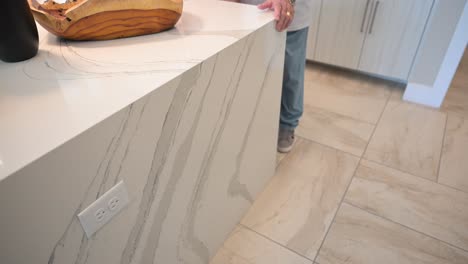 loving senior couple smile and give an approval to the new kitchen area with white marble countertop and modern contemporary style