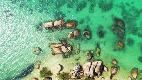 Amazing-limestone-cliffs-caved-by-clear-water-of-turquoise-lagoon-near-shore-of-tropical-island-in-Ko-Tao,-Thailand