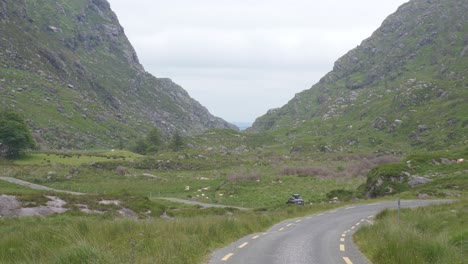 Coche-Que-Viaja-En-El-Sinuoso-Camino-De-La-Brecha-De-Dunloe-En-El-Parque-Nacional-De-Killarney-En-Irlanda