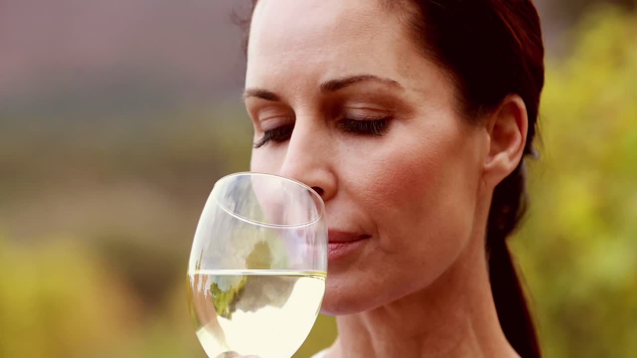 Viticoltrice che fa roteare un bicchiere di vino bianco