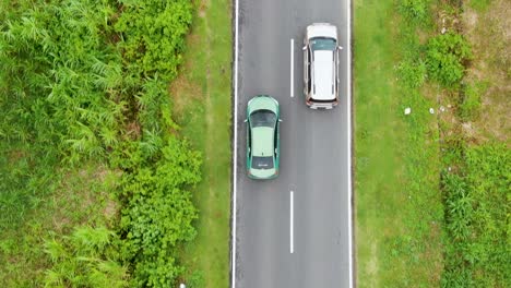 Cars-and-motorcycle-driving-along-country-road-in-rural-area-of-Kembumen-in-Indonesia