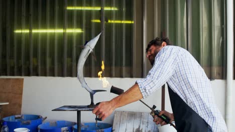 artesano preparando una escultura de pescado 4k