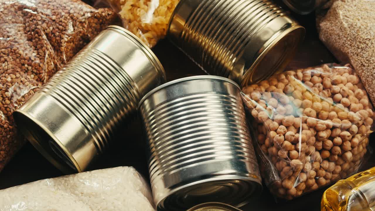 Canned cereals beans fish and vegetables, an assortment of processed foods, supermarket cart online shopping, delivery.