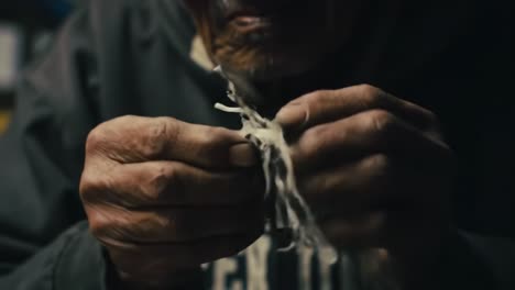 an elderly artisan skillfully crafts a traditional figure from twisted material, showcasing a rich cultural heritage through intricate handwork and attention to detail