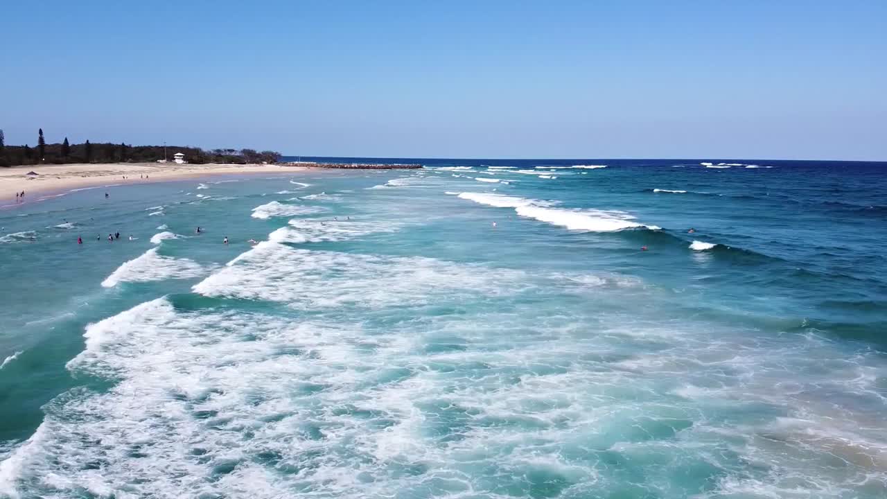 Aerial View of People Swimming and Surfing in the Ocean on a Sunny Day