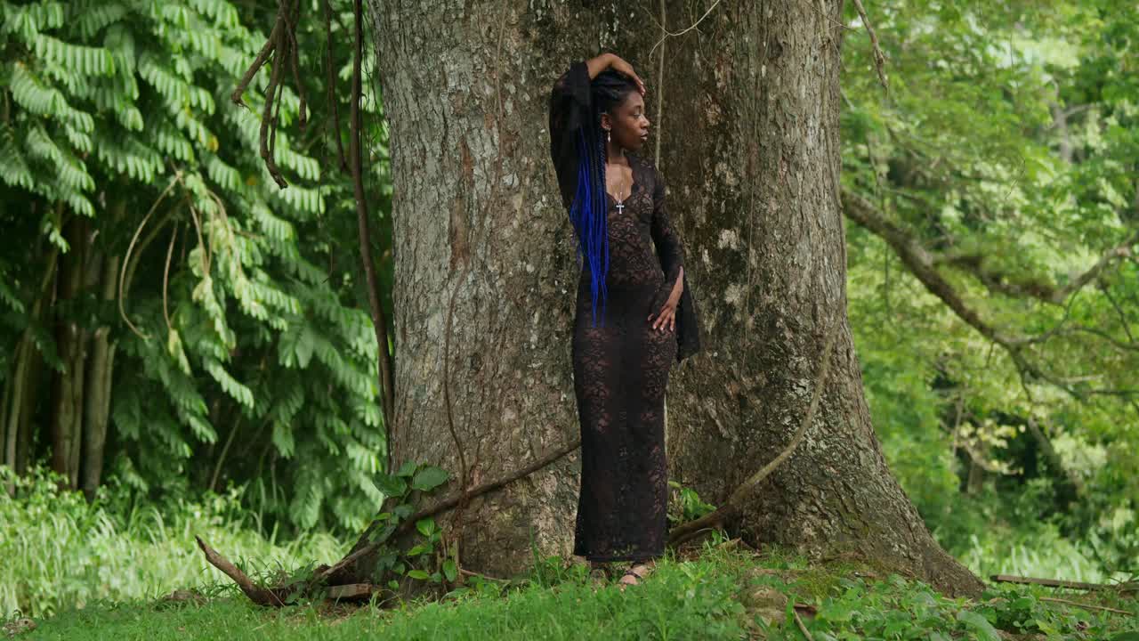 Beautiful Woman in Black Lace Dress Posing in Lush Tropical Forest