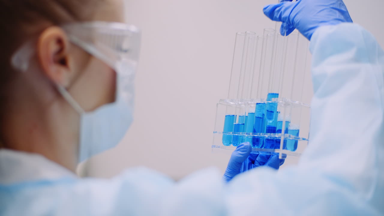 Scienziata che tiene provette e beuta con liquido in mano 12
