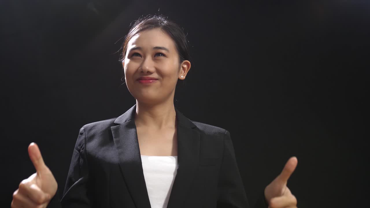 자신감 넘치는 사업가 여성이 엄지손가락을 올리고 있습니다.