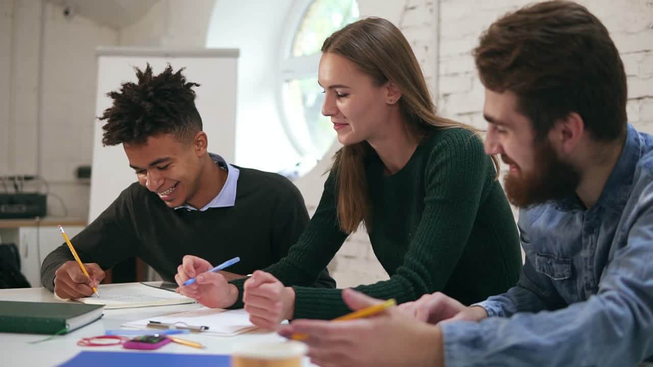 Happy diverse group of students or young business team working on a project. Young african guy showing the results of his work