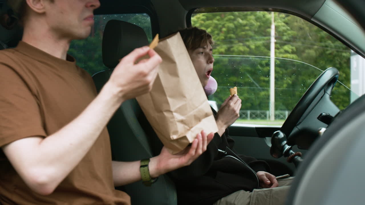 친구들이 밴에서 간식을 먹고 있습니다.