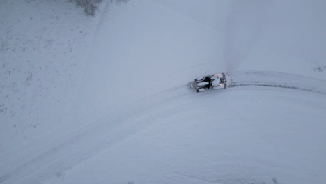 Luftaufnahme-Eines-Traktors,-Der-Die-Straße-Nach-Einem-Schneesturm-In-Der-Arktischen-Winterlandschaft-Räumt