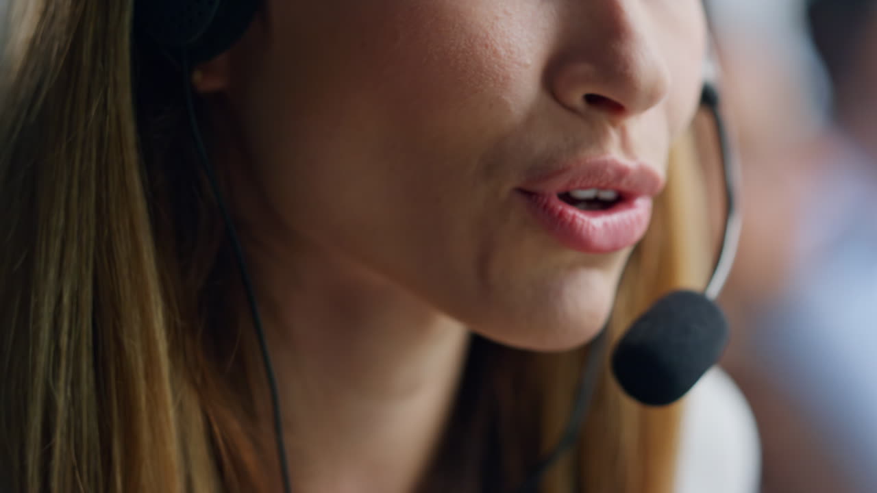 Nærbilde: Operatørlepper snakker i mikrofon. Telemarketingagent veileder kunde.