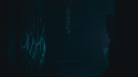 Mysterious man in the workshop at night smokes a cigarette