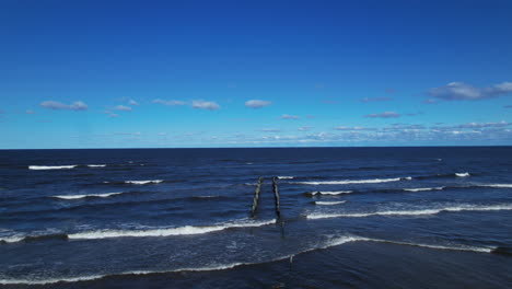 a wooden post sticking out of the ocean