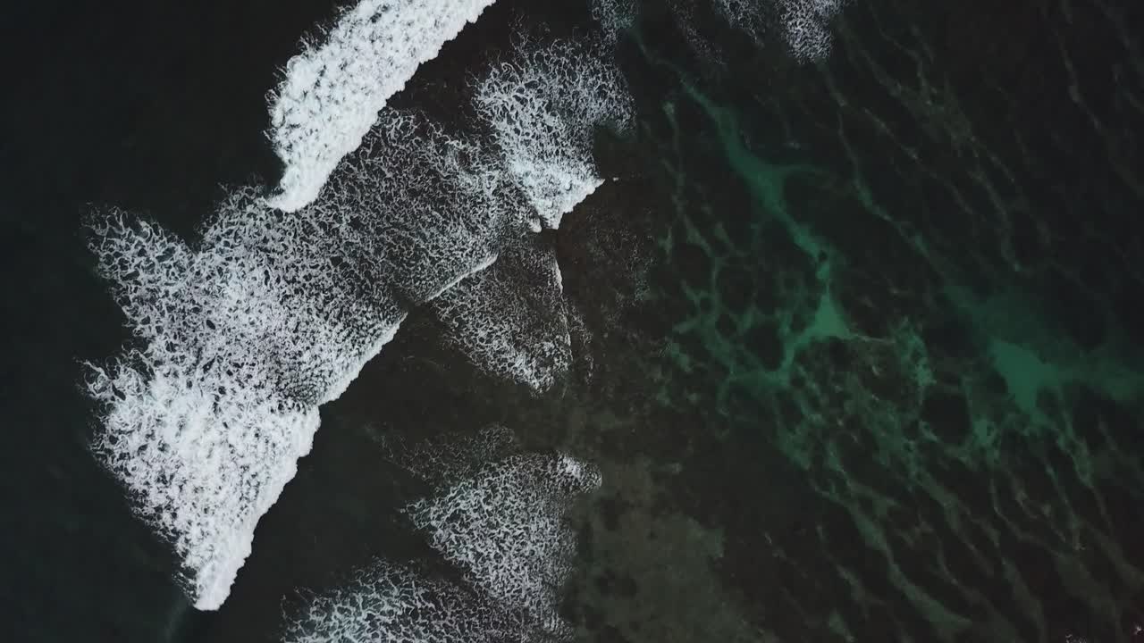 Drone above waves crashing on rocks in Kauai, Hawaii