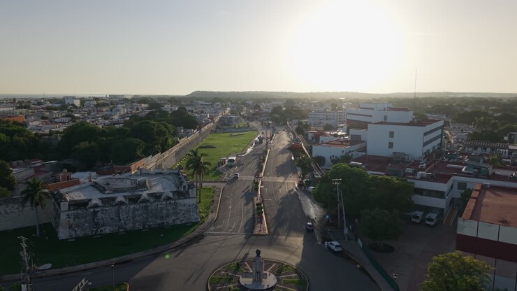 Ripresa aerea con drone che vola verso l’alba con vista panoramica sul Baluarte de San Juan e sulle mura della città di Campeche, in Messico