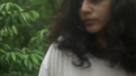 Medium-close-up-of-tan-woman-looking-around-in-lush-tropical-forest