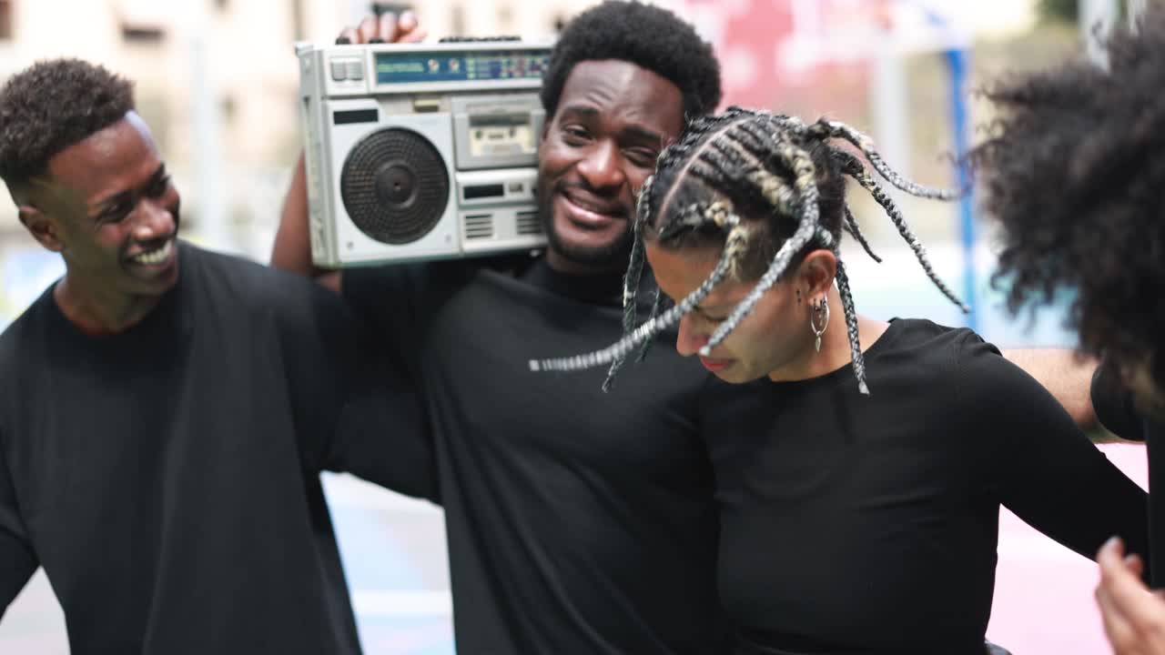 Group of young african people listening music from vintage boombox stereo outdoor