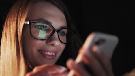 mujer usando teléfono inteligente por la noche