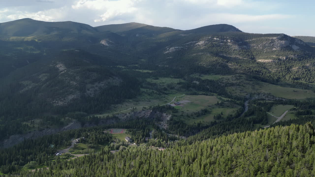 una cordillera sombreada se eleva sobre el campamento de verano en el bosque de pinos
