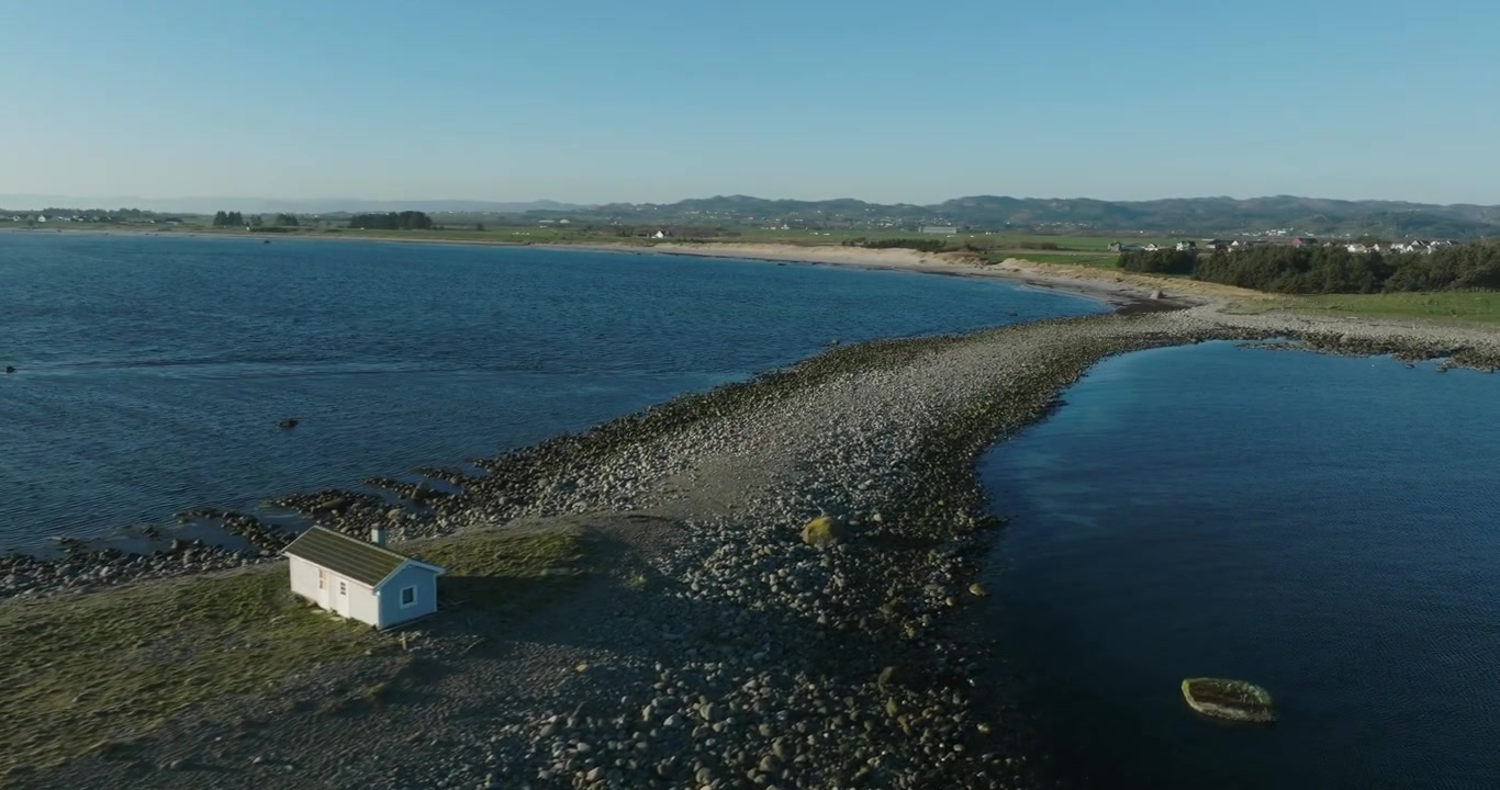 Spiaggia costiera con ciottoli e pozze di marea a Vestbygd, Norvegia.