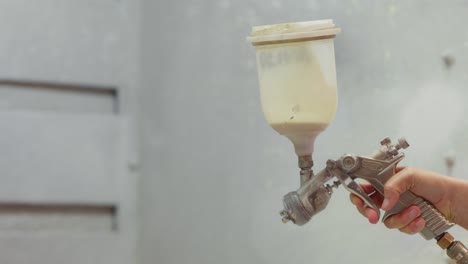 Hand-holding-a-spray-gun-in-the-workshop