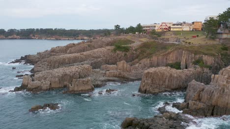 Aerial-pan-shot-of-Tojinbo-Coastal-Cliffs-Japan's-Volcanic-Causeway