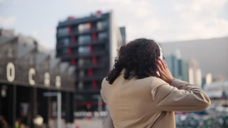 mujer feliz disfrutando de la música en la ciudad