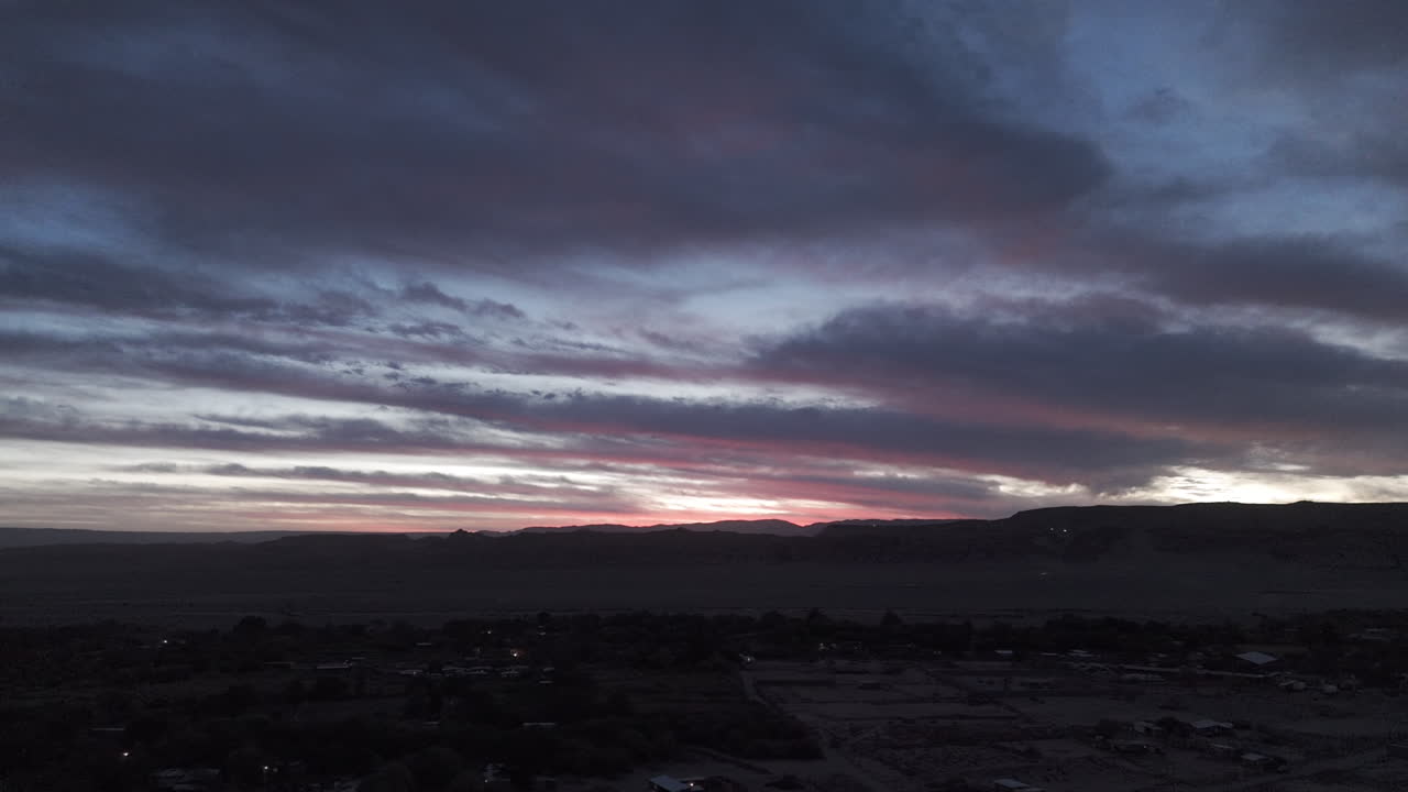 Sideways flying drone shot above San Pedro de Atacama Chile South America on a clear day and purple sky with mountains in the background during sunset LOG