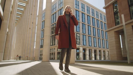 businessman walking outdoors and speaking on phone