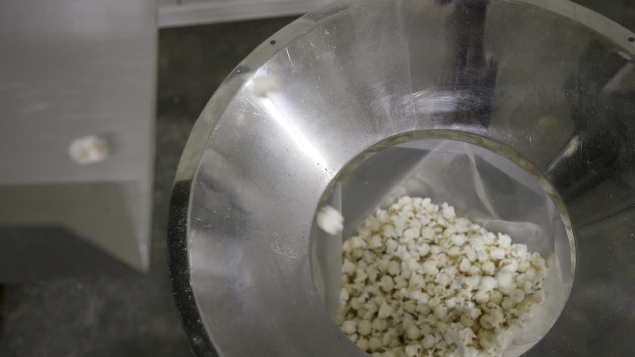 컨베이어 에서 가방 에 떨어지는 팝콘 의  ⁇