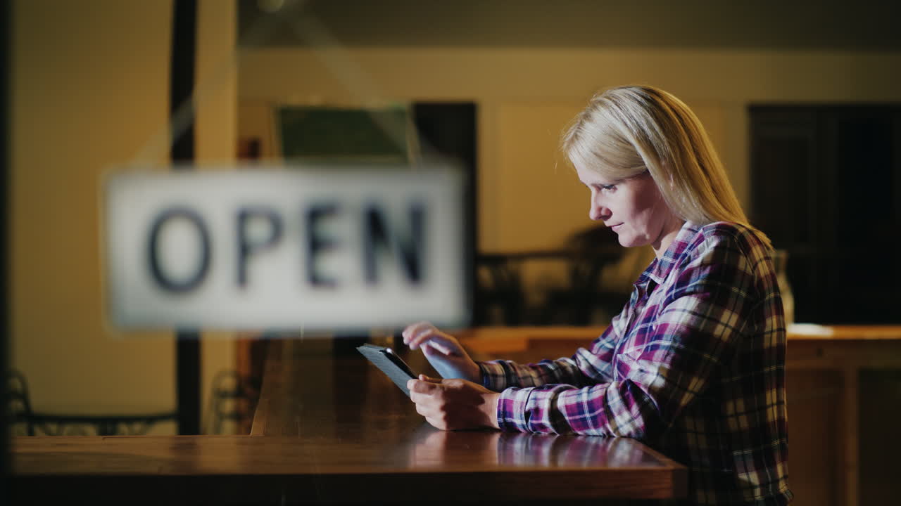 mujer señora de la limpieza limpia la barra en el bar después de cerrar