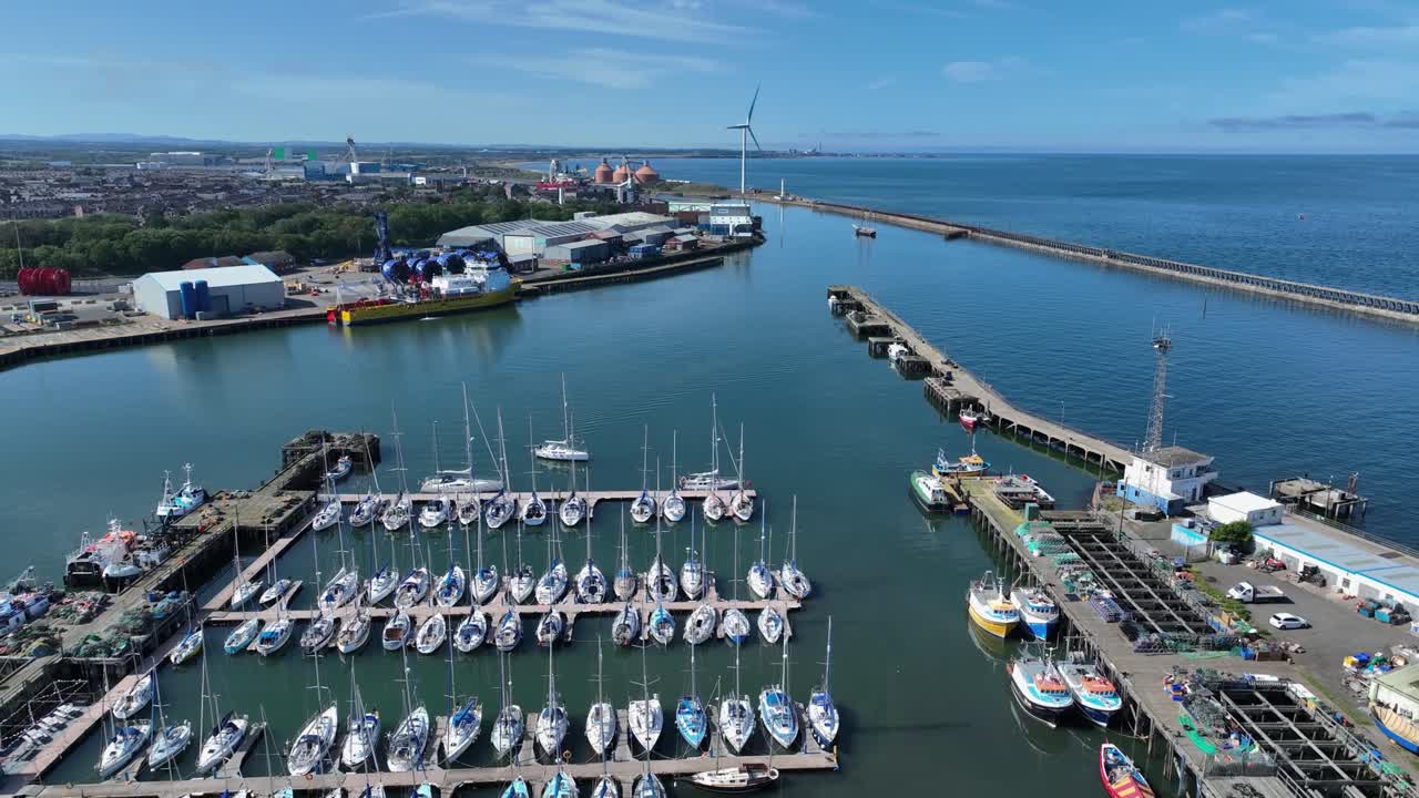 Drone view showing modern industrial harbour with boat marina and wind turbine