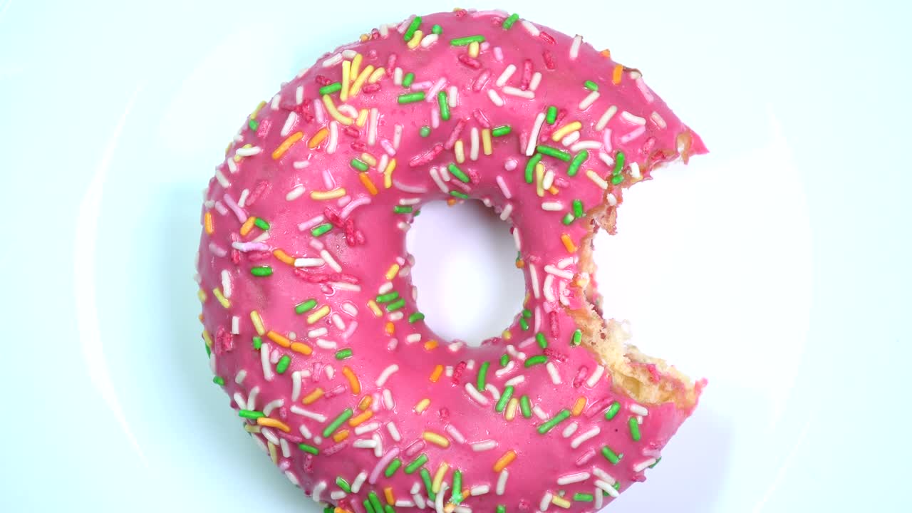 alguien mordió una rosquilla con salpicaduras. yummy girando lentamente en una mesa giratoria.