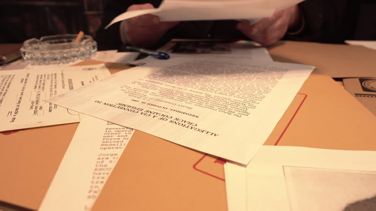 Detective Looking at Investigation and Top Secret Files and Document at Office Desk, Close Up