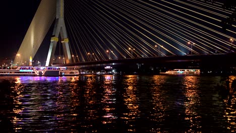 recreational boats with lights are deployed on the river under the cable bridge. part 2